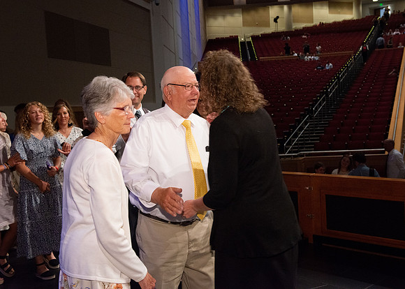 Sister Heather Hall huging her family after devotional.