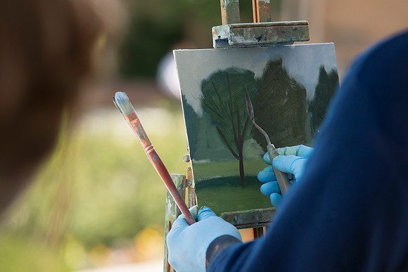 Brother Bodily gives a painting demonstration during his Oil Painting class outside the Spori Building.