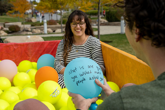 Students who volunteer to participate sit in the ball pit and ask each other questions which are found on the balloons. Video is being produced for Student Living.