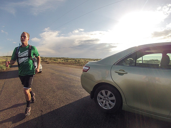 Jimmy Newell weaves between support vehicles to get to a turn to continue his run.