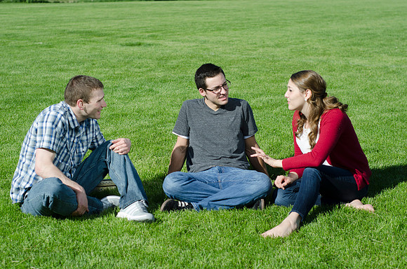 Three friends laugh and enjoy talking on a sunny morning.