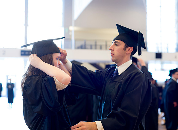 Graduates wait inside the gym area preparing to enter Commencement ceremony.