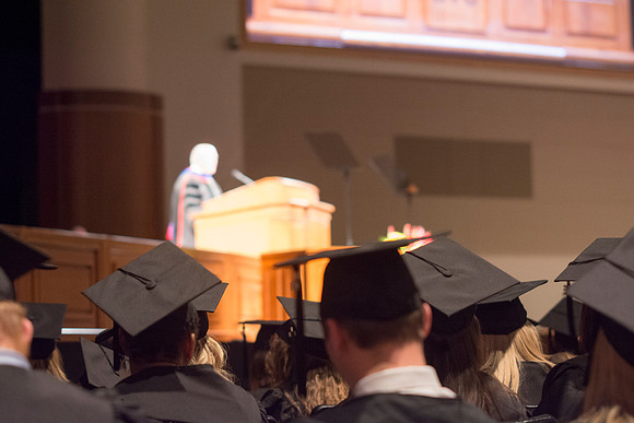 Students listen to speakers at the Brigham Young University-Idaho commencement ceremony with fellow peers.