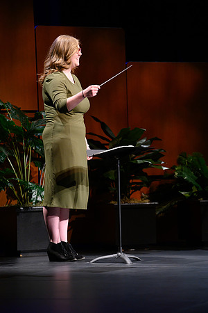 Student conducting closing hymn at the end of devotional.