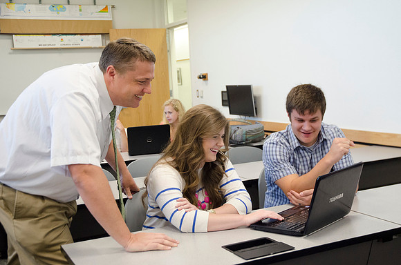 Matt Miles helps students work on group project.