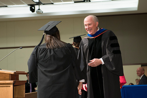 Elder Maynes congratulates the graduates in the College of Language and Letters Convocation in the Manwaring Center Ballroom.