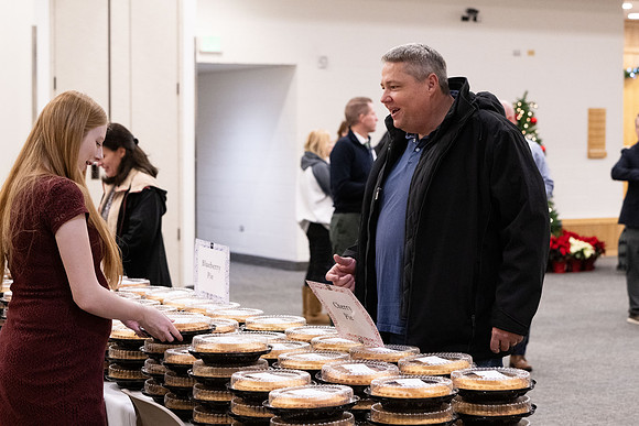 Employees gather for the annual Christmas gathering with President and Sister Meredith.