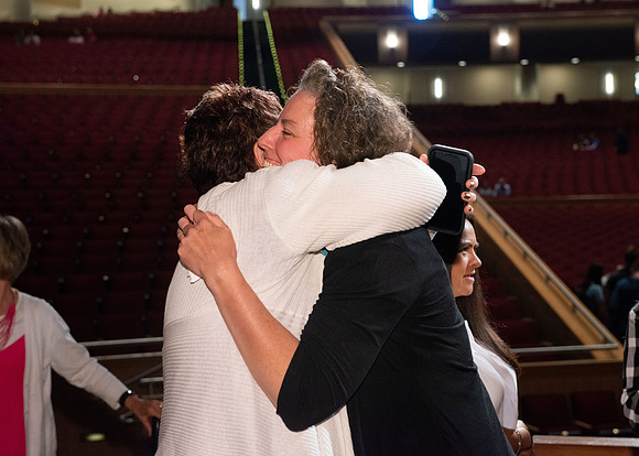 Sister Heather Hall huging her family after devotional.
