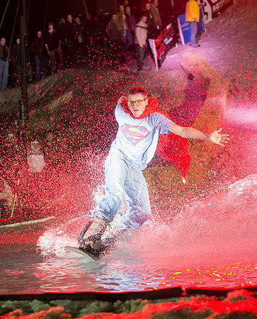 Students make a run down a snowy slope and across a pond of water in the annual event of Pond Skimming.