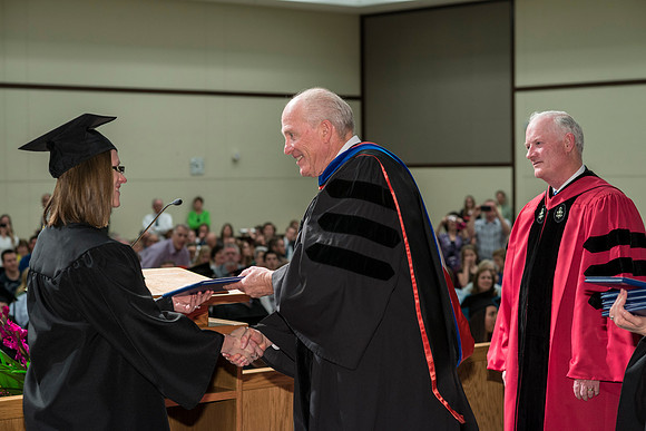 Elder Maynes and Pres Clark congratulate the graduates in the College of Language and Letters Convocation in the Manwaring Center Ballroom.