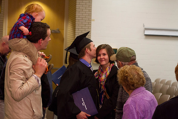 A graduate kisses a loved one after convocation in the Taylor Building.