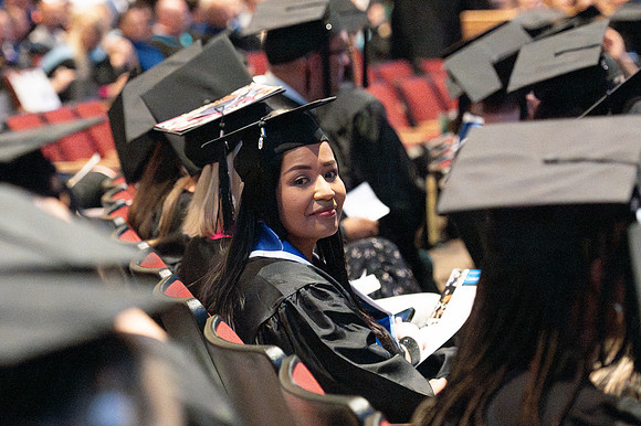 Brother Timothy Rarick laughs with graduates during convocation for the College of Education & Human Development