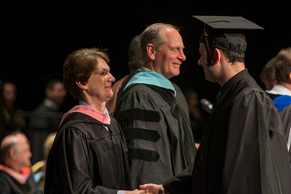 Faculty members hand degrees to and congratualate graduates of the College of Performing and Visual Arts.