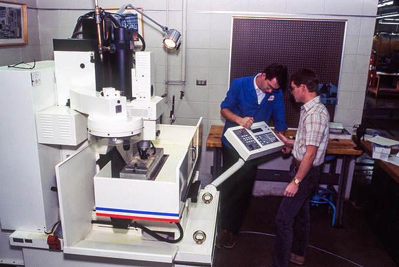 Teacher and Student work alonside one another with Manufacturing Technology. December 1990.