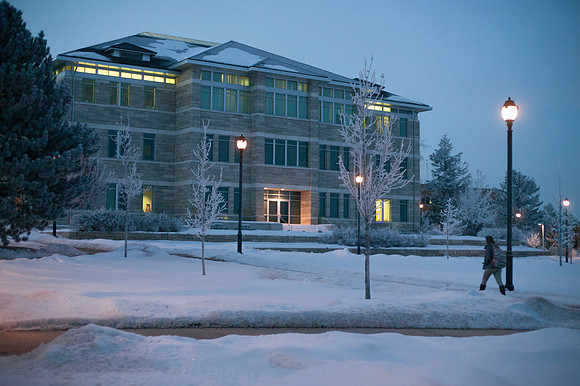 Fog sourrounds the Spori building as a student walks to their early morning class.