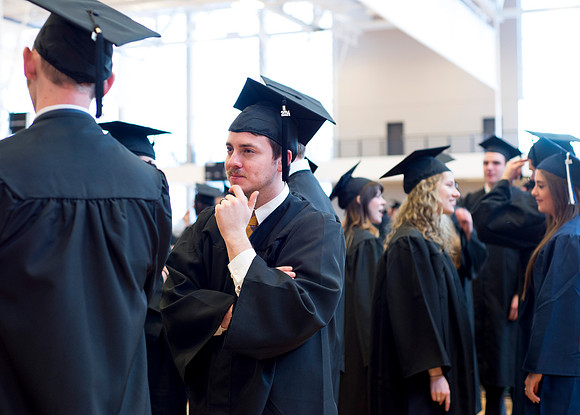 Graduates wait inside the gym area preparing to enter Commencement ceremony.