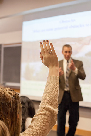 A student raises her hand to ask a question in Brother Madsen's Geography For Elementary Teachers class.