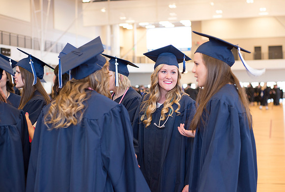 Graduates wait inside the gym area preparing to enter Commencement ceremony.