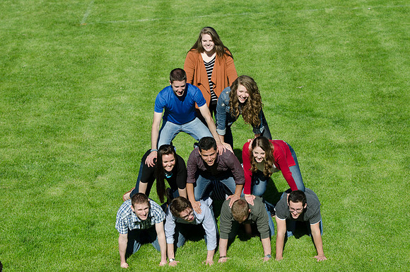 Students build and topple in a human pyramid.