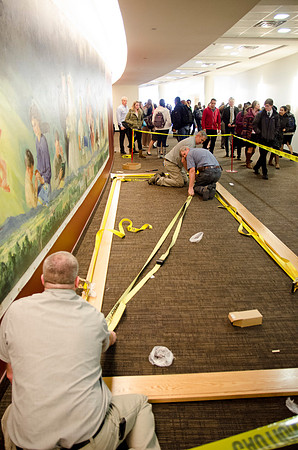 Campus faculty glues together the frame that will encompass a new mural in the I-Center Lobby.