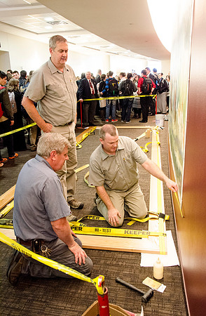 Campus faculty glues together the frame that will encompass a new mural in the I-Center Lobby.