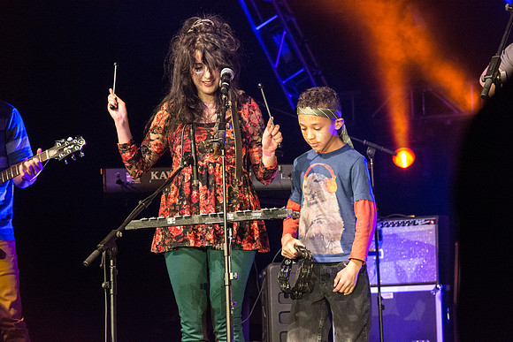 A local kid, Justin, performs with his music teacher, Emma Huntington and her band, The Locals, the Big Rock Show.