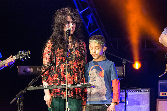 A local kid, Justin, performs with his music teacher, Emma Huntington and her band, The Locals, the Big Rock Show.