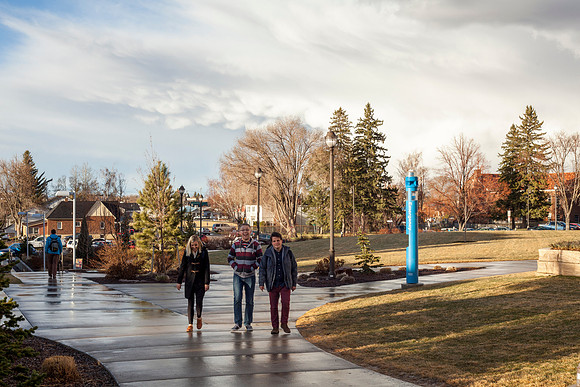 Students walk to and from home on campus as the sun sets after a rainstorm.