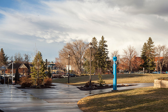 Students walk to and from home on campus as the sun sets after a rainstorm.