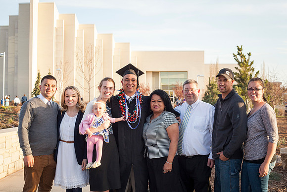 A graduate from BYU-Idaho gathers outside with his family after the commencement ceremony in the I-Center. Photo by Tyler D. Rickenbach.