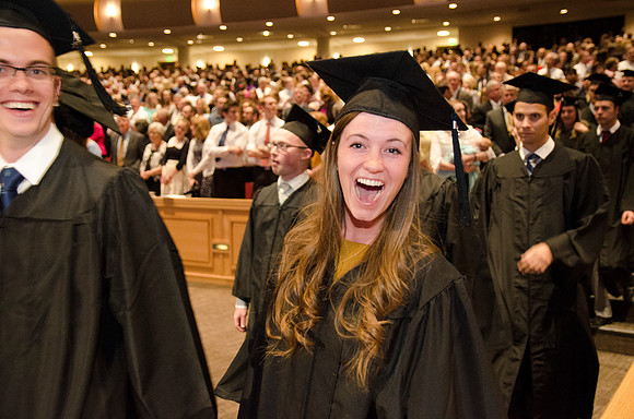 An excited graduate shows her emotion during processional. Photo by Erik Hill.