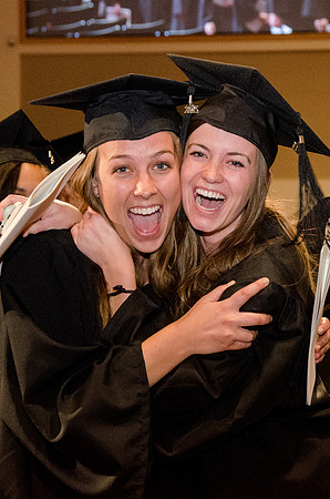 Two students celebrate on recieving their Degrees. Photo by Erik HIll.