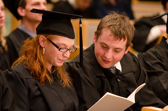 Graduates search for thier names in the Convocation program. Photo by Erik HIll.