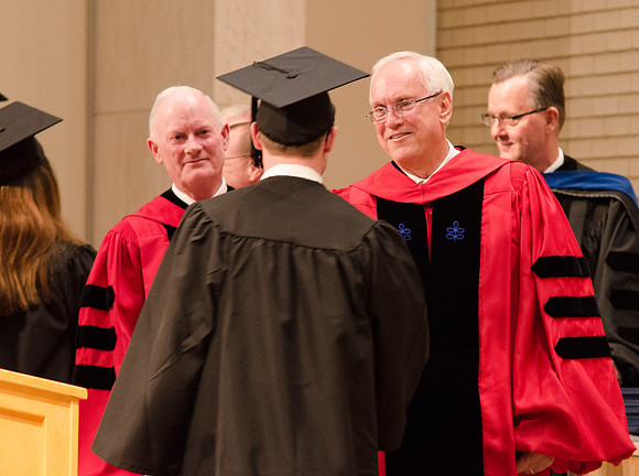 Elder Robert C. Gay and President Kim B. Clark congratulate a Graduate. Photo by Erik Hill.