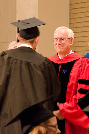 Elder Robert C. Gay of the first Quorum of the Seventy congratulates and shakes the hand of a Graduate. Photo by Erik Hill.