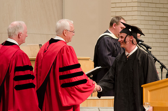 Elder Robert C. Gay and President Kim B. Clark congratulate a Graduate. Photo by Erik Hill.