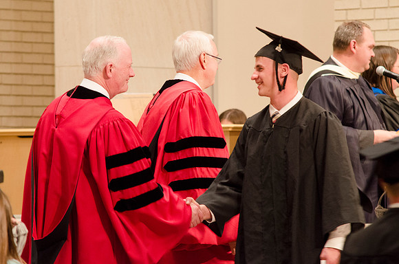 Elder Robert C. Gay and President Kim B. Clark congratulate a Graduate. Photo by Erik Hill.
