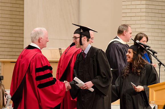 Elder Robert C. Gay and President Kim B. Clark congratulate the Hubert Family. Photo by Erik Hill.
