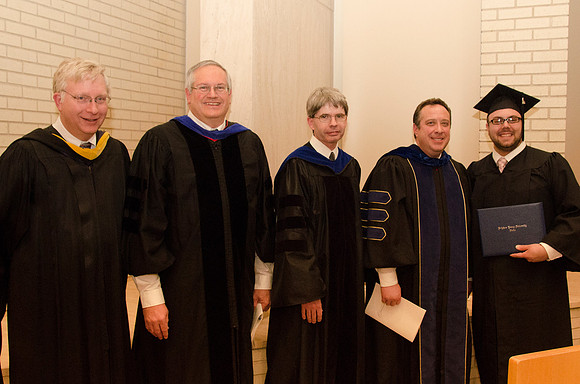 A Graduate poses with some of his past teachers at the end of the Convocation Ceremony.