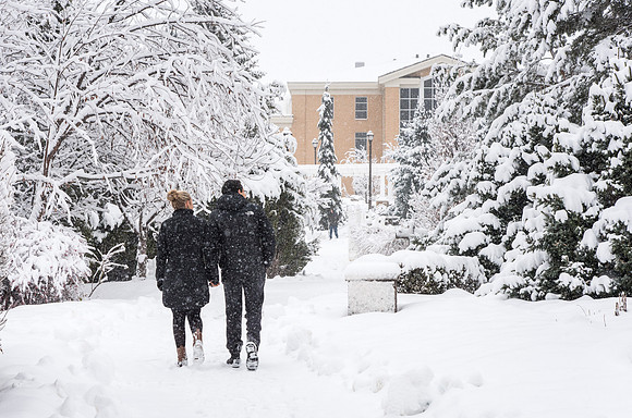 BYU-Idaho campus becomes a Winter Wonderland on graduation day. Carlos and Elizabeth Palomares stroll through the gardens.