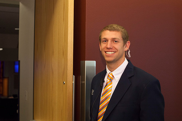 An usher at graduation stands eagerly at the door to greet family and frineds as they are welcomed into the I-Center.