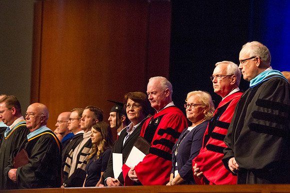 Speaker at April Commencement Elder Robert C. Gay along with Elder Paul V. Johnson and President and Sister Clark, gather on the stand in the I-Center.