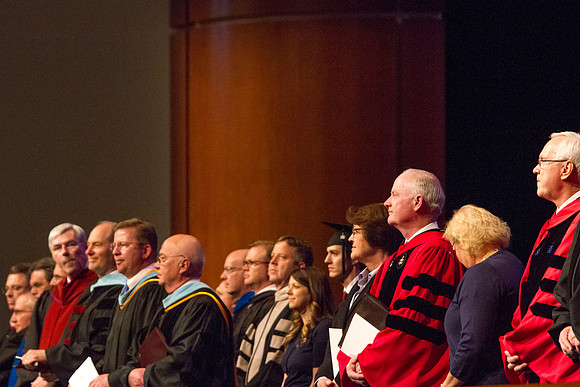 Speaker at April Commencement Elder Robert C. Gay along with Elder Paul V. Johnson and President and Sister Clark, gather on the stand in the I-Center.