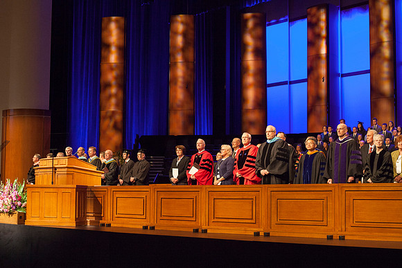 Speaker at April Commencement Elder Robert C. Gay along with Elder Paul V. Johnson and President and Sister Clark, gather on the stand in the I-Center.