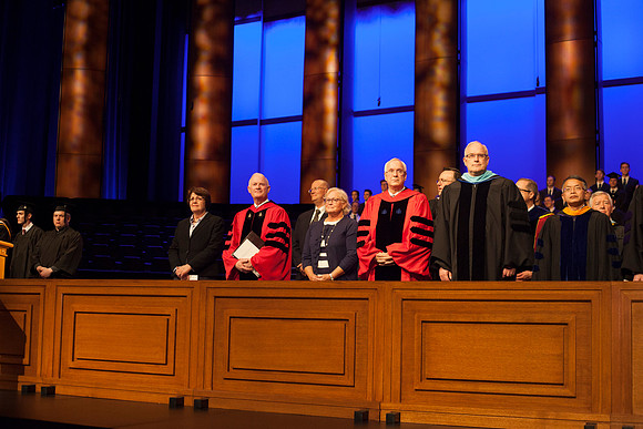 Speaker at April Commencement, Elder Robert C. Gay along with Elder Paul V. Johnson and President and Sister Clark, gather on the stand in the I-Center.