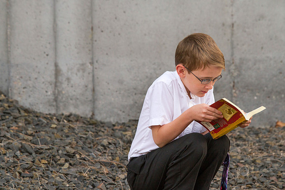 A child reads a book outside the I-Center after the Commencement Ceremony.