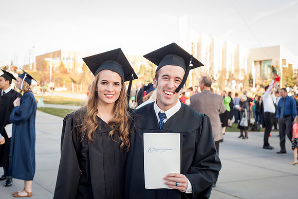 Graduates smile outside the I-Center after the April Commencement Ceremony.