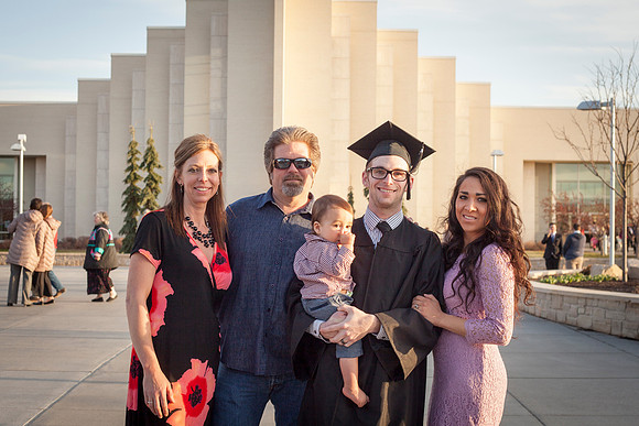 A graduate from BYU-Idaho gathers outside with his family after the Commencement Ceremony, in front of the Taylor Building. Photo by Tyler D. Rickenbach