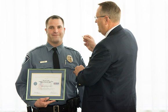 Garth Gunderson, University Security and Safety Director present a pin representing his award to Bryan Lyons.