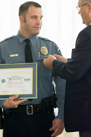 Garth Gunderson, University Security and Safety Director present a pin representing his award to Bryan Lyons.